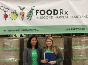 Two people smiling under Food RX sign