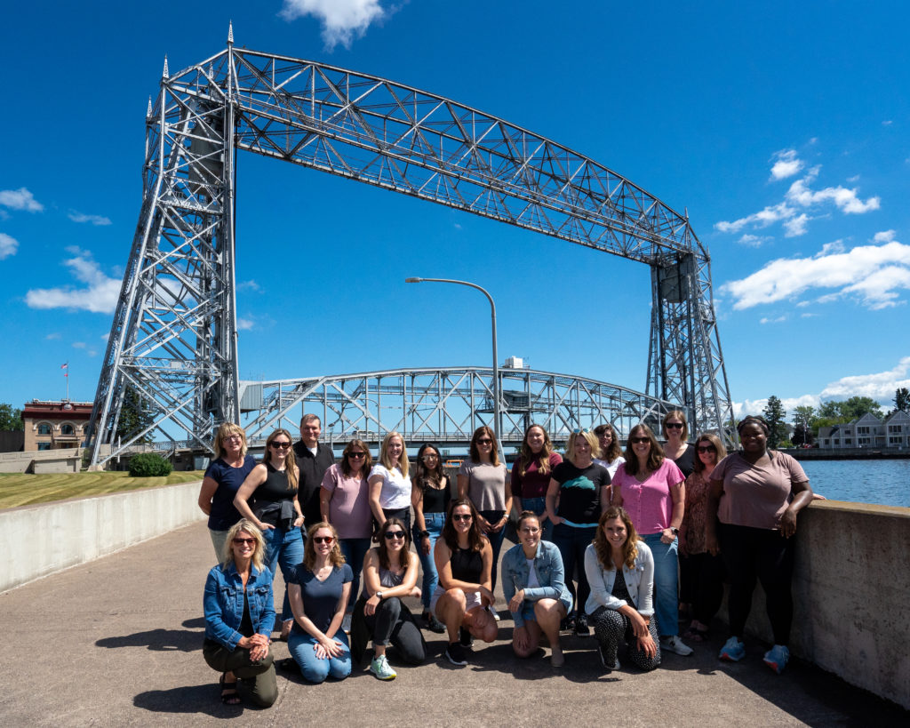 A group of people pose in front of a liftbridge