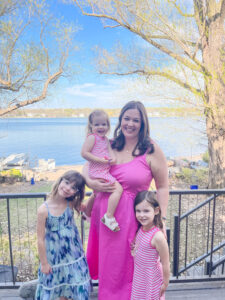 Megan D. stands on a deck with her three daughters