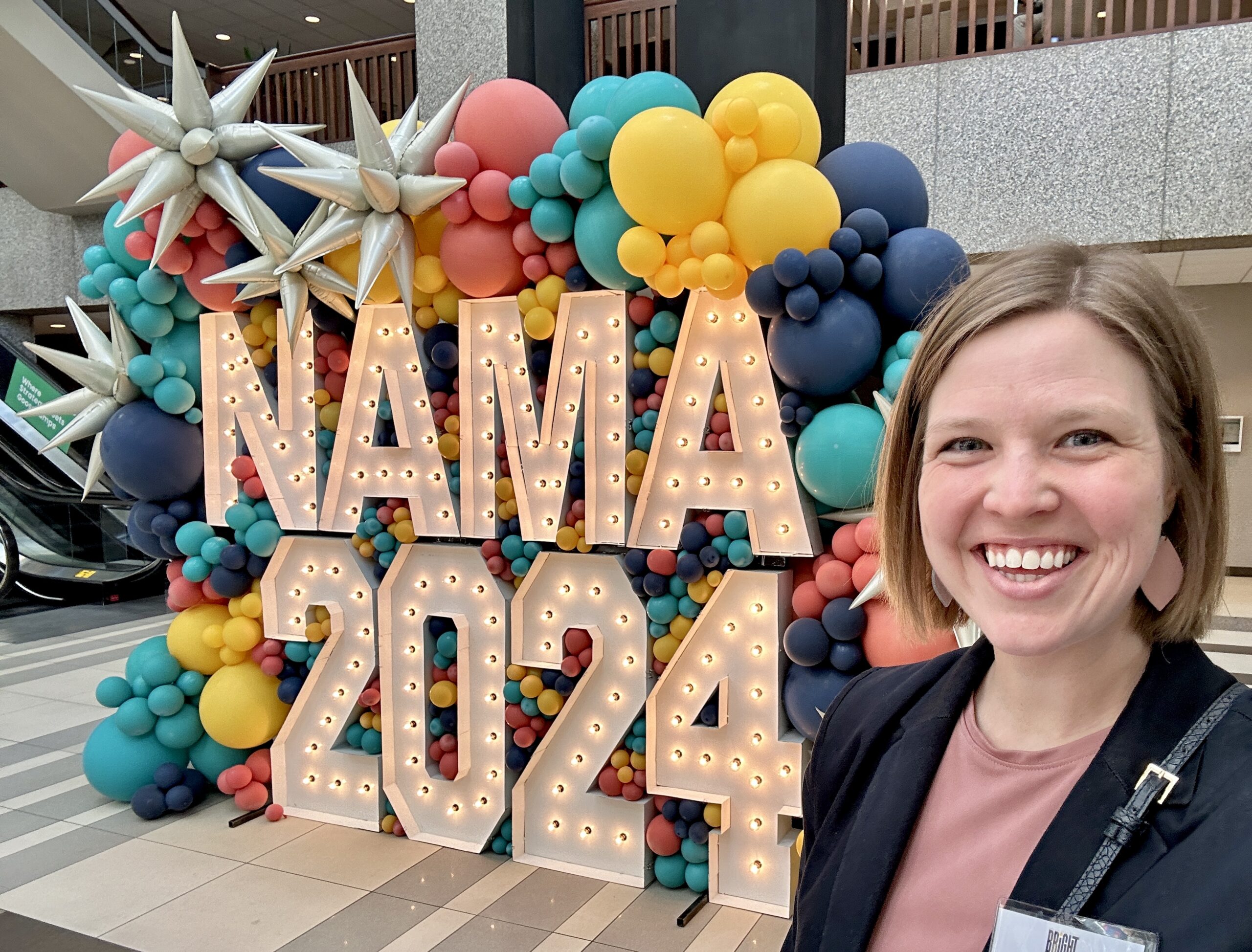 Sara snaps a selfie with decorations at a business conference